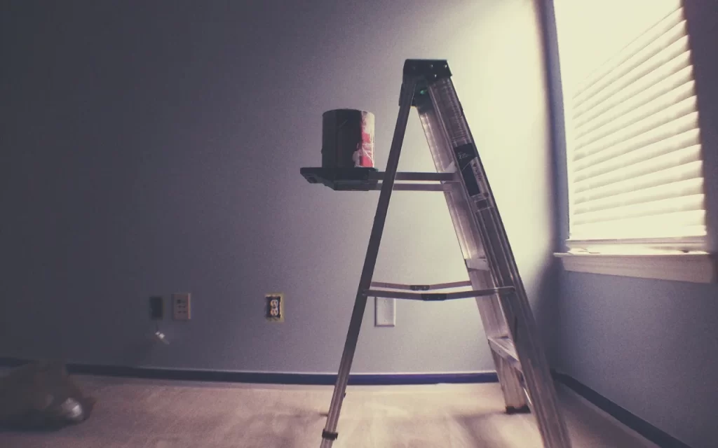 Close-up of a hand applying primer to a wall with a roller