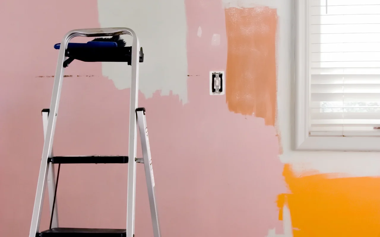Person sanding a wall to prepare it for painting